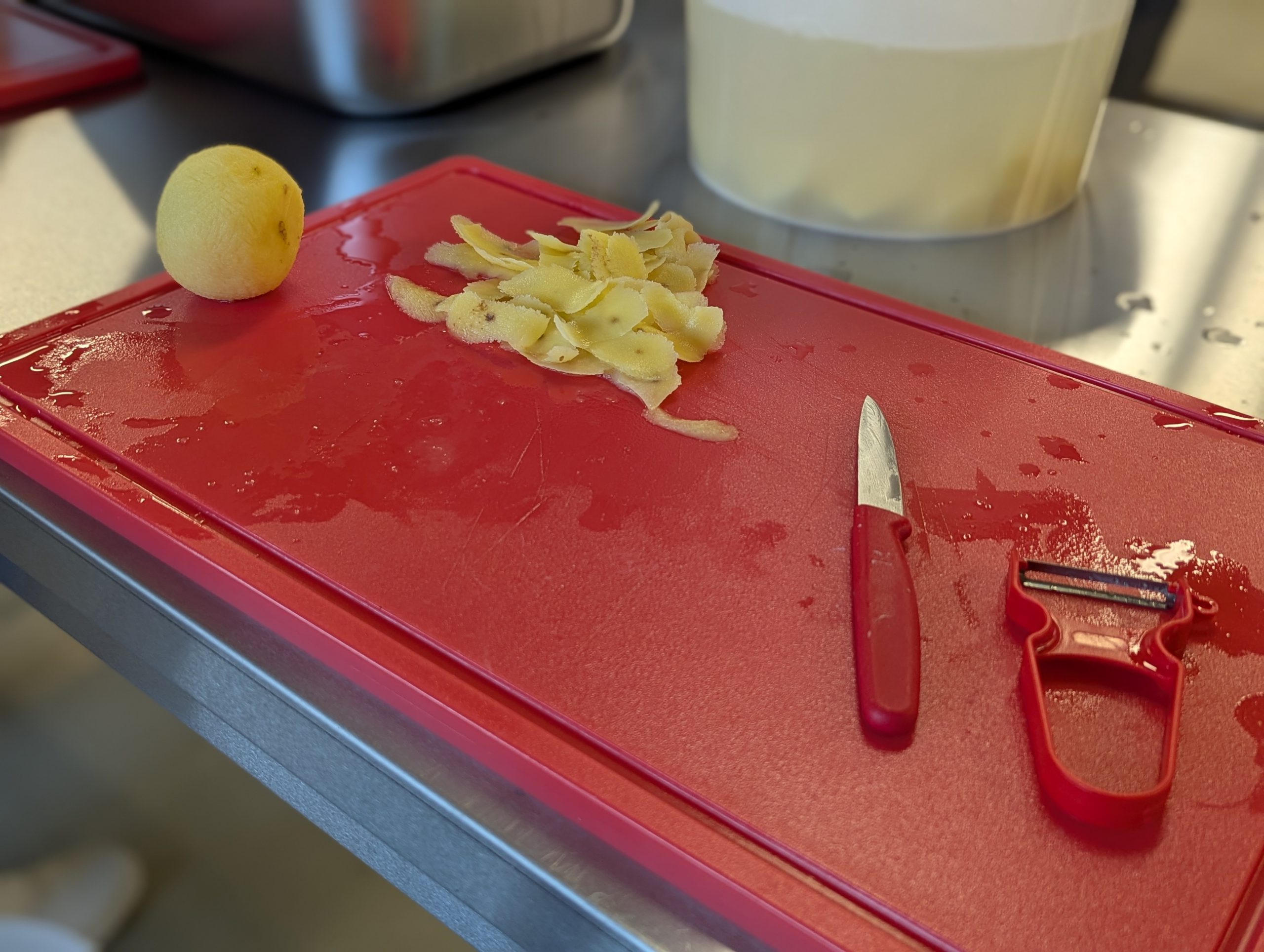 Küchenbrett mit Messer und Kartoffelschäler